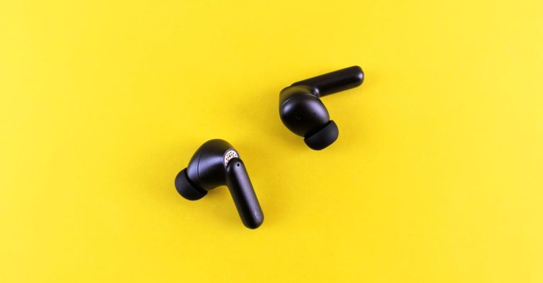Minimalist black wireless earbuds on a bright yellow backdrop for tech and lifestyle themes.