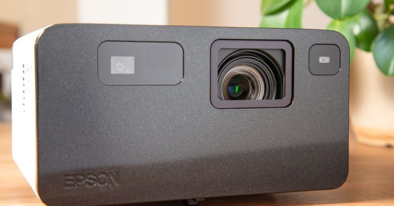 High-quality product shot of a modern Epson projector on a wooden table with indoor plants.