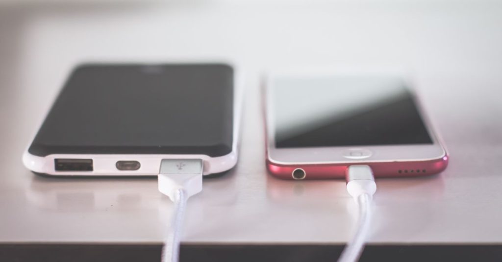 Two smartphones charging side by side on a desk. Modern and technological setting.