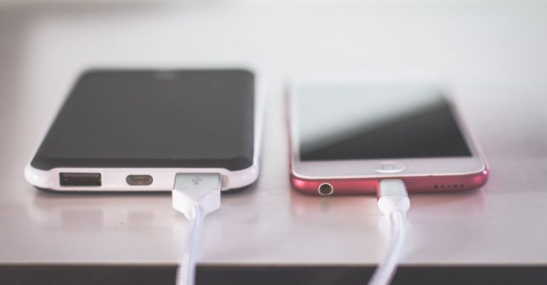 Two smartphones charging side by side on a desk. Modern and technological setting.