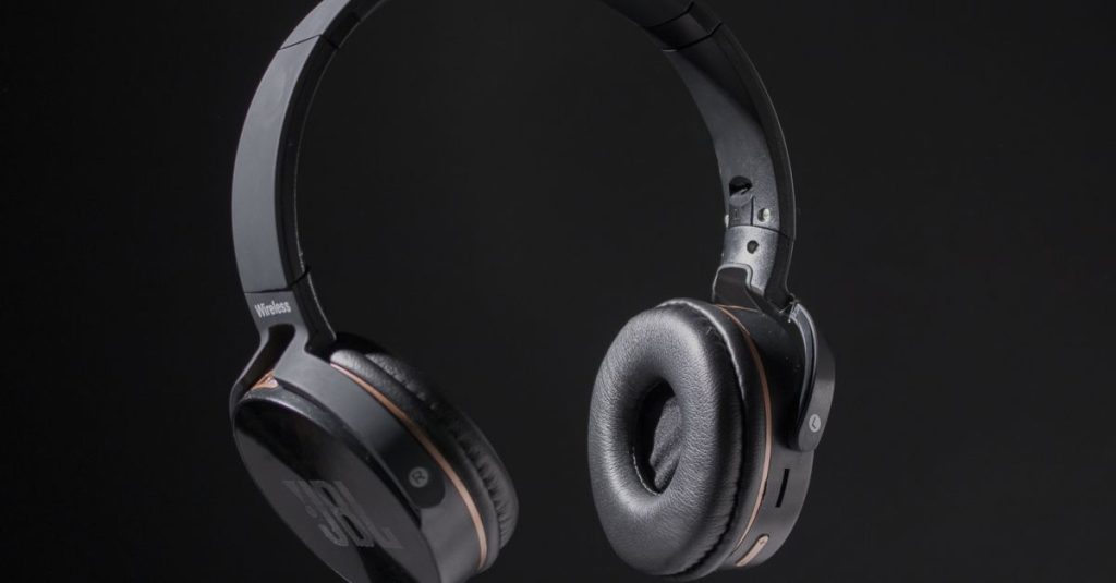 Close-up of wireless headphones on a dark background, showcasing design and texture.