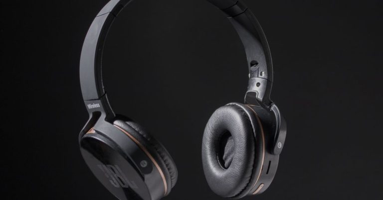 Close-up of wireless headphones on a dark background, showcasing design and texture.
