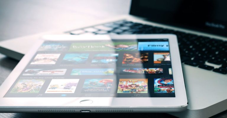 Tablet displaying streaming services on a laptop, illustrating digital entertainment setup.