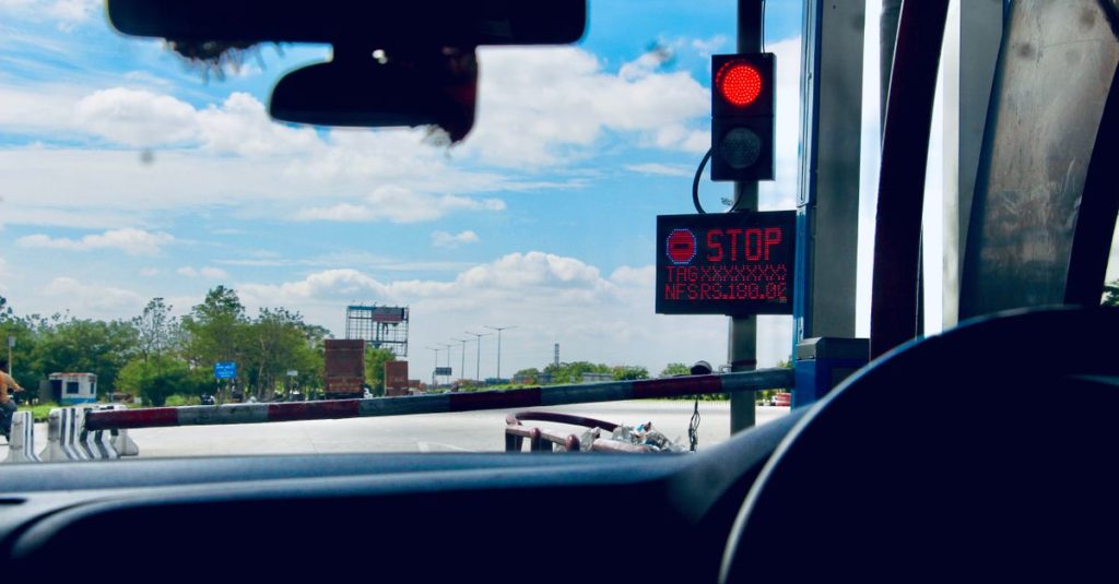 Car interior view at a toll booth in Suryapet, India with a stoplight.