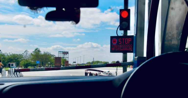 Car interior view at a toll booth in Suryapet, India with a stoplight.