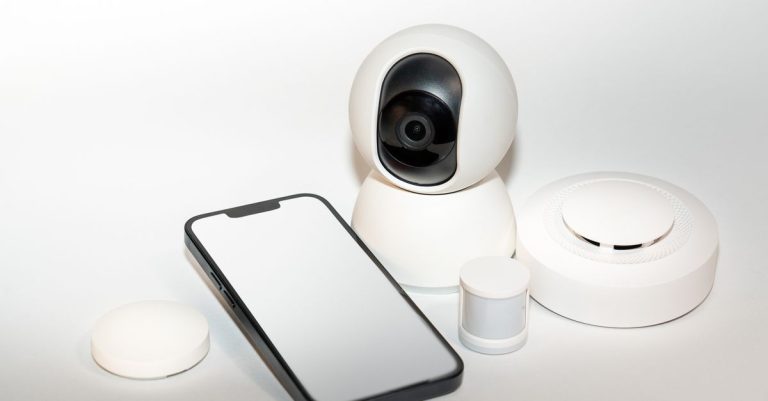 Collection of smart home security gadgets with a smartphone display.