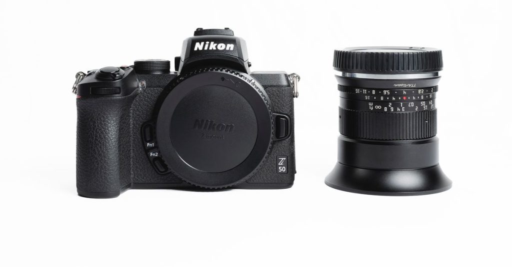 Nikon mirrorless camera and lens displayed on a white surface.
