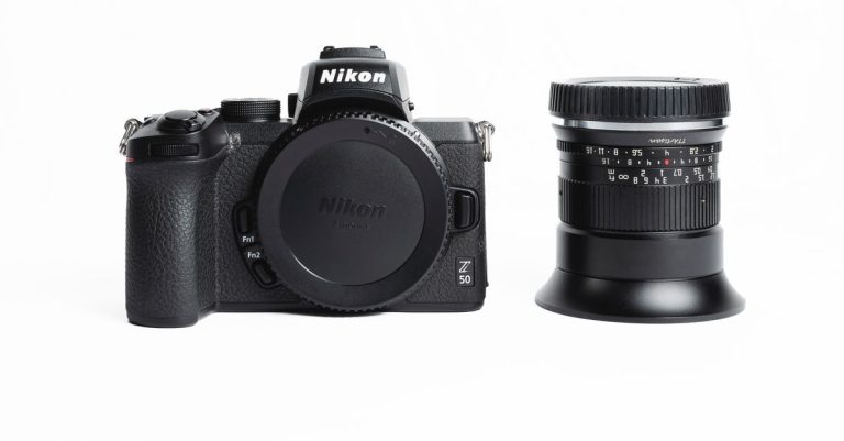 Nikon mirrorless camera and lens displayed on a white surface.