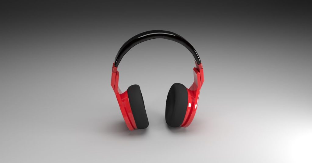 Vibrant red headphones isolated on a smooth gray gradient background, perfect for music and technology themes.