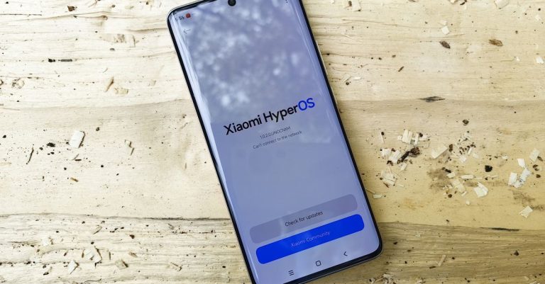 Modern Xiaomi smartphone displaying HyperOS on a rustic wooden surface, showcasing technology innovation.